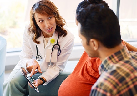 doctor meets with pregnant couple