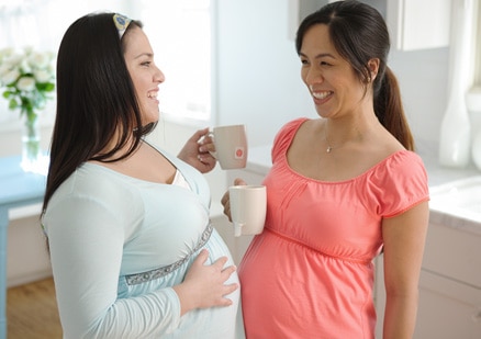 2 pregnant women smiling