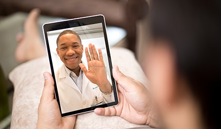 Person meeting doctor virtually on a tablet